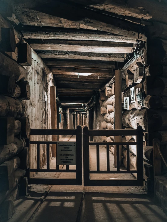 a long wood pathway next to a stone wall