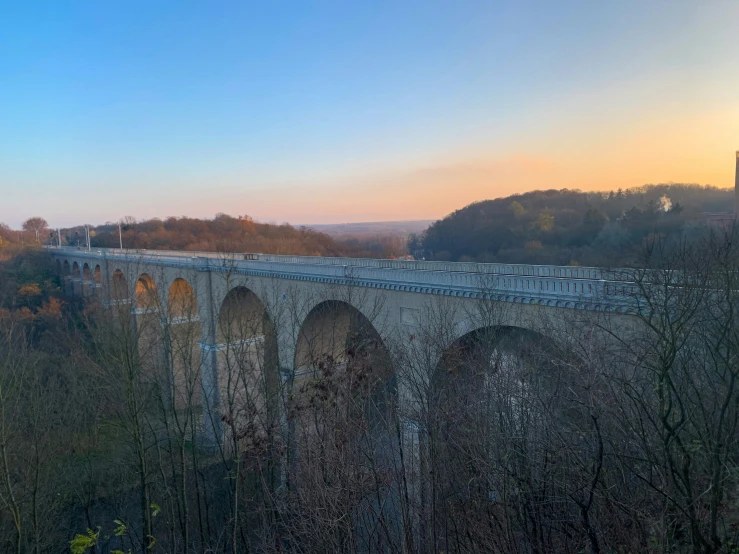 train crosses the bridge with autumn colors in the background