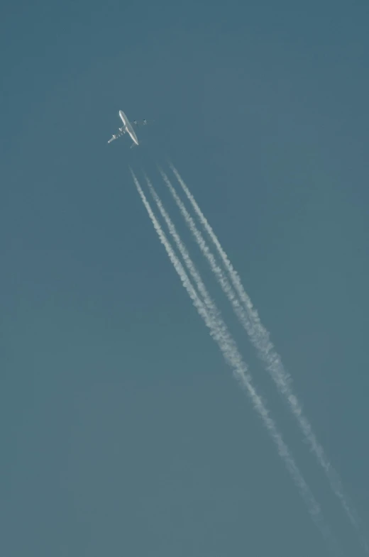 two jet airplanes are leaving contrails behind them