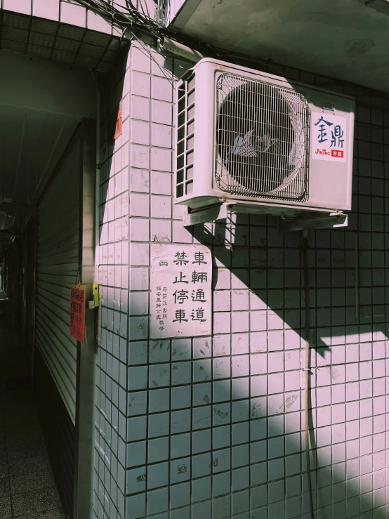 a white air conditioner mounted on a wall in an alley