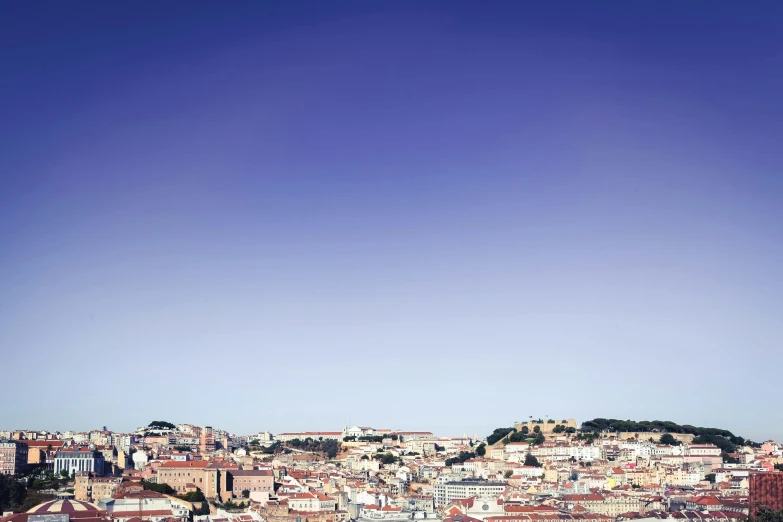 a cityscape from the mountains below in the sun