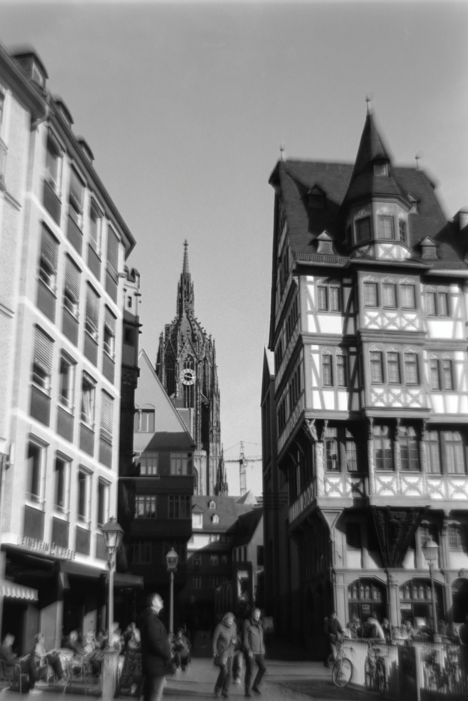 people walking around a town with several tall buildings