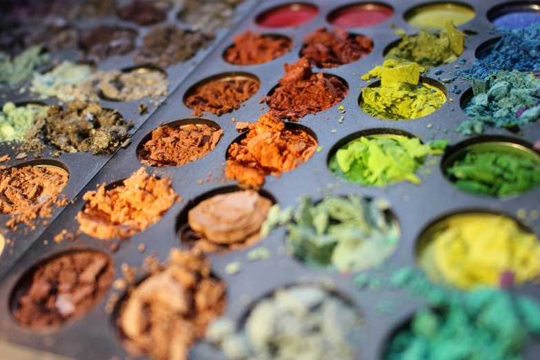 different colors of powder arranged in rows, on a tray