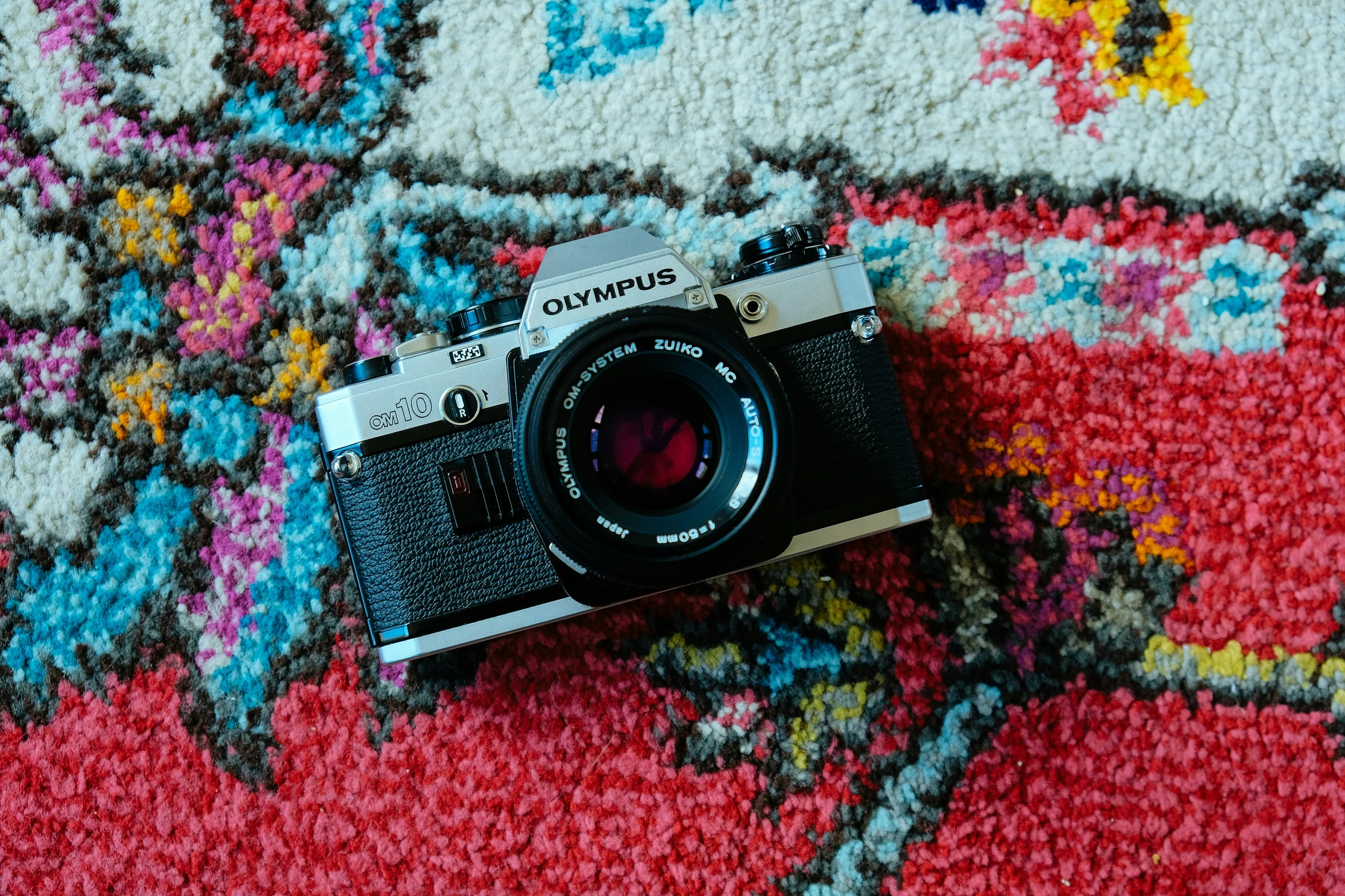 a camera sitting on a rug covered in rugs