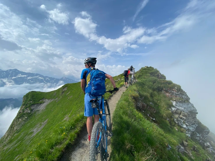 a group of mountain bikers trekking along a narrow path