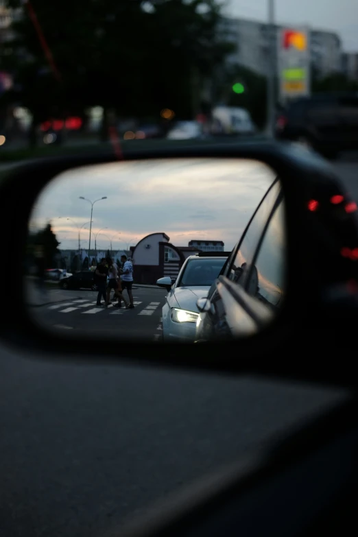 people in cars looking in the side view mirror