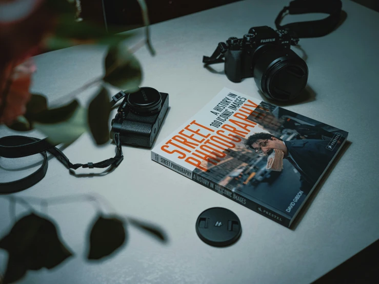 the book is sitting on a table by a camera