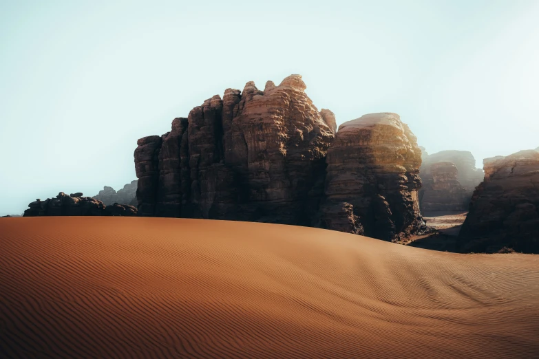 sand and rock formations with the sun shining on them