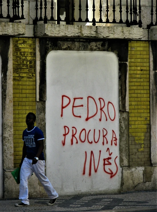 a person walking past an old building and spray painted words