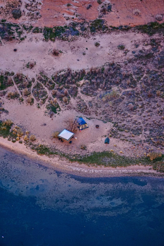 an aerial view of a house sitting next to water