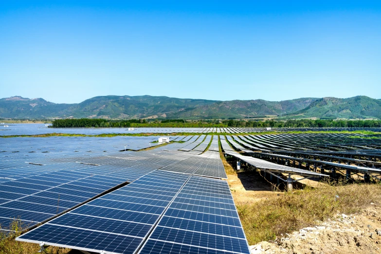 a number of rows of solar panels near water