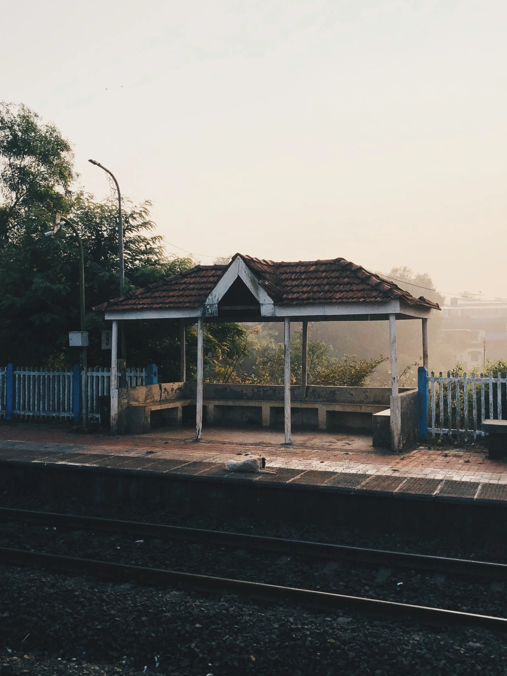 the gazebo sits on the side of the railroad tracks