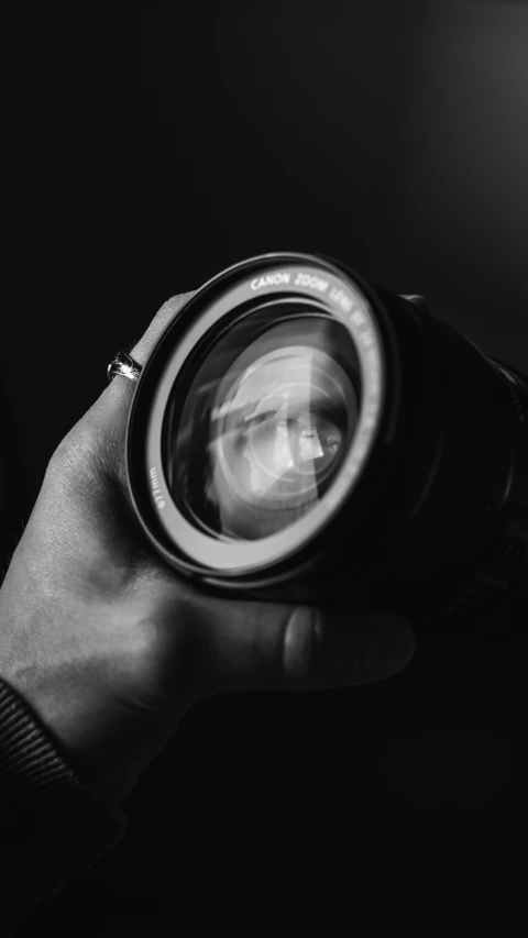 a person holding a camera lens in their hand