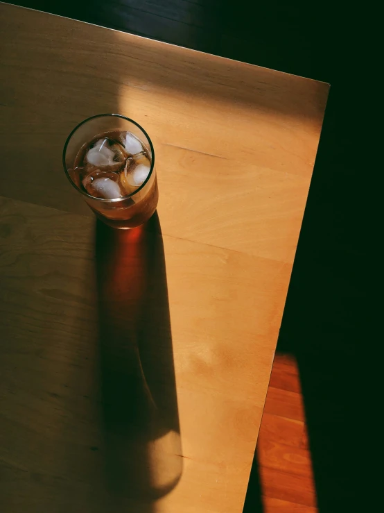 a glass of water with ice is placed on a table