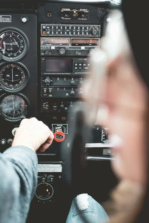 a woman is flying in a plane with the pilot's hands on the controls panel