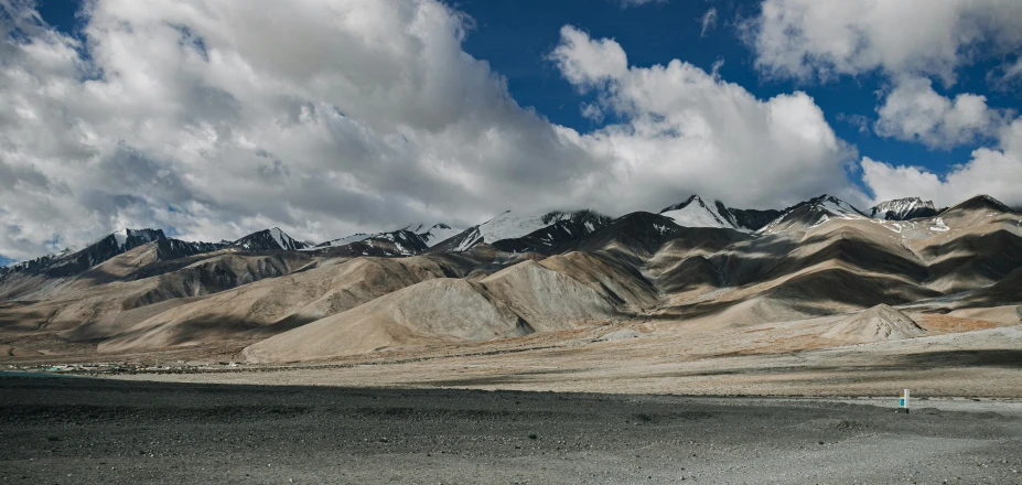 a po taken at the base of the mountains, the sky is cloudy