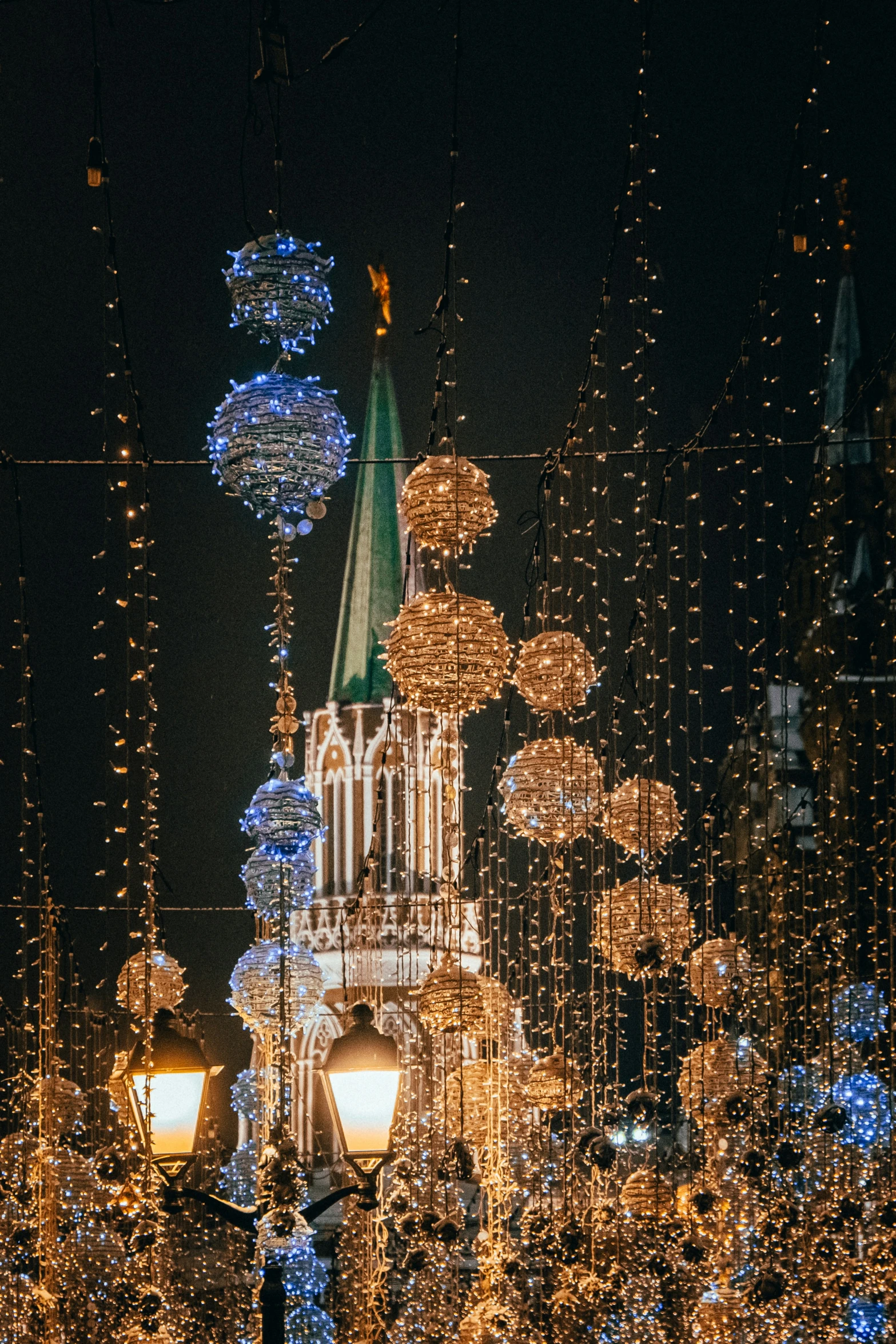 there is an old church with christmas lights on the front and it is illuminated in gold