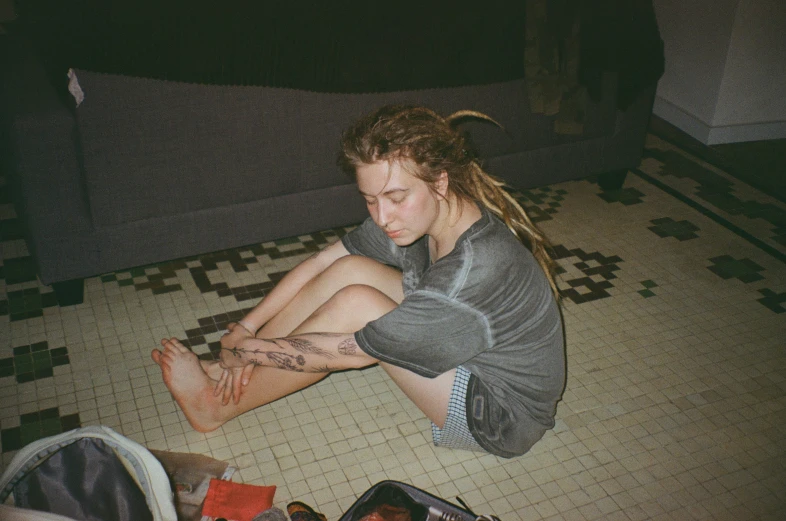 a man with long dreadlocks sitting on the floor