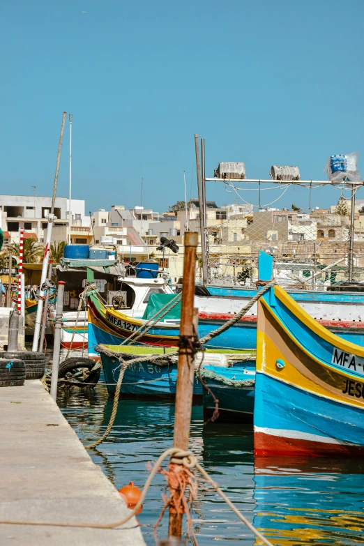 boats moored in a harbor surrounded by other city buildings