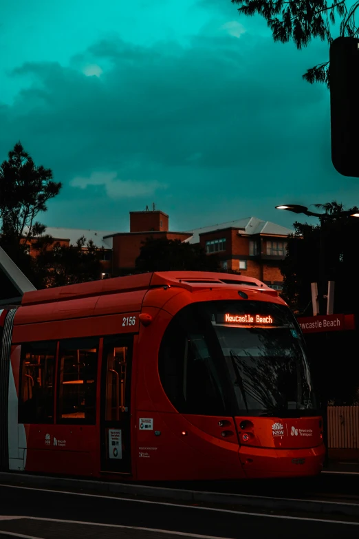 red city tram with black lights and dark clouds