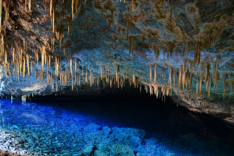 a po taken in a large cave with a blue pool