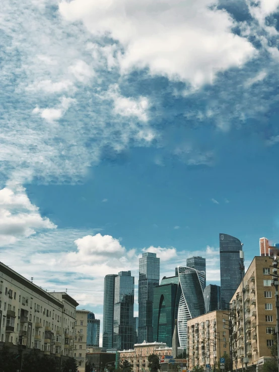 tall buildings against blue skies and clouds in the background