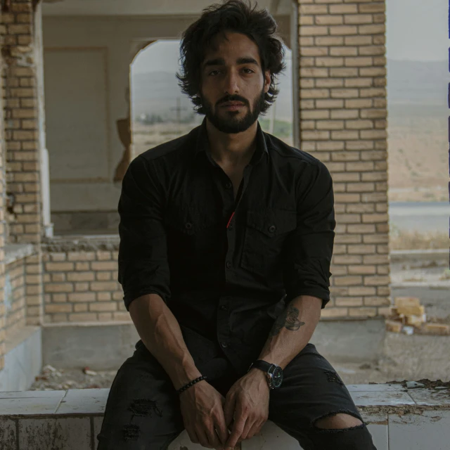 a man sitting on a wall in an abandoned building