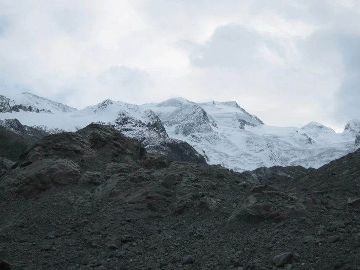 the large snow covered mountains are seen on this cloudy day