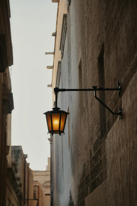 a lamp on the side of a building along a city street