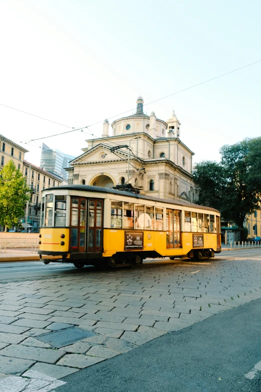 the trolley car is driving down the street