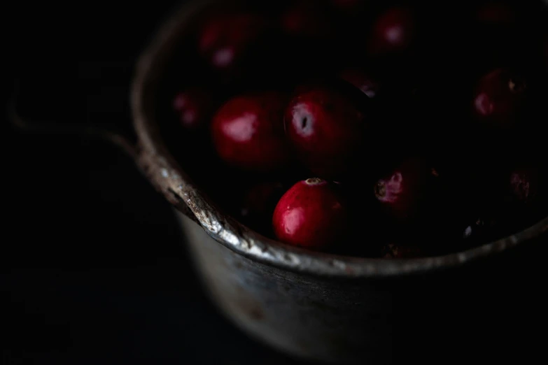 two metal pans filled with cranberries on a table