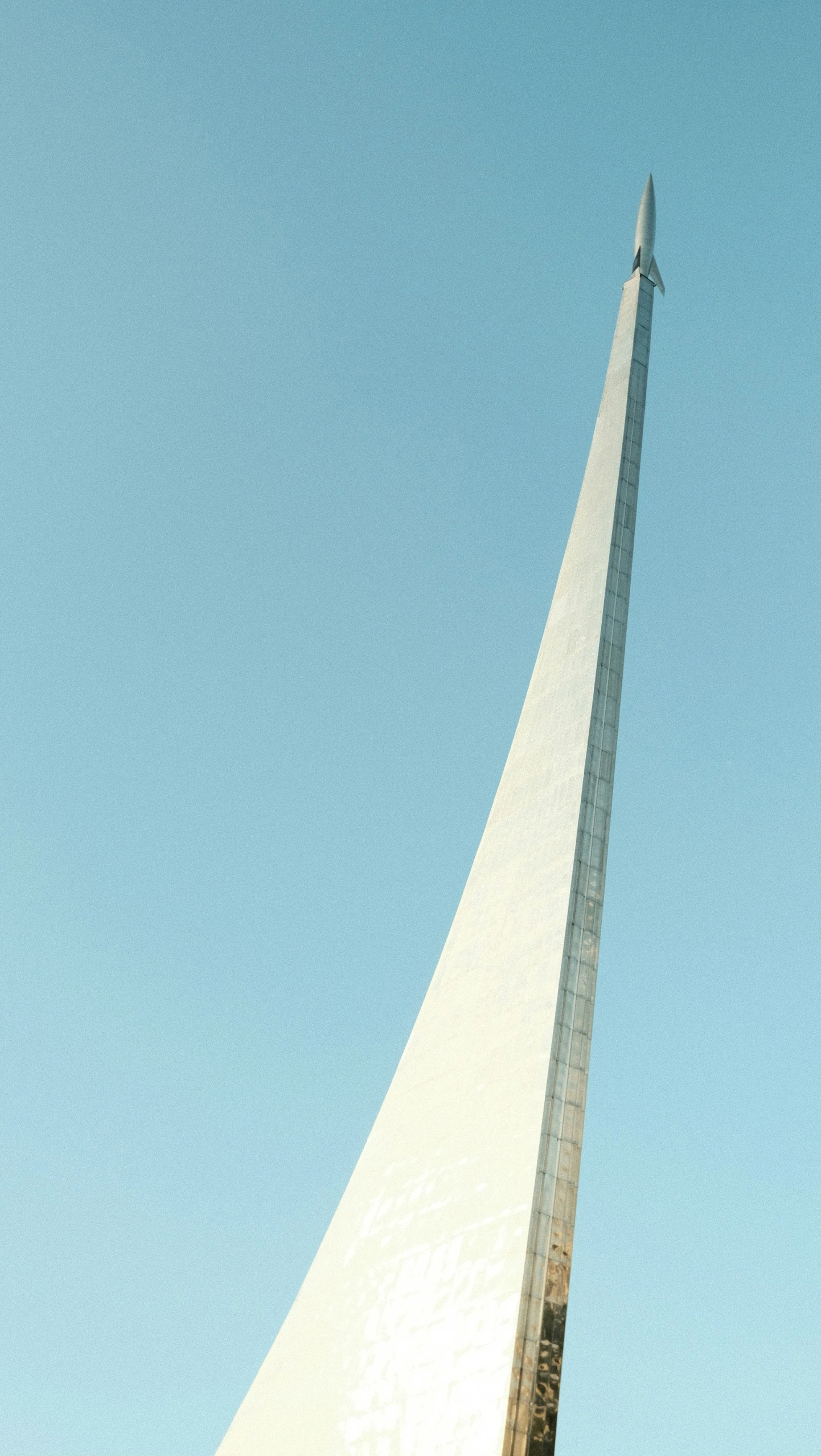 an airplane is flying over the monument on a sunny day