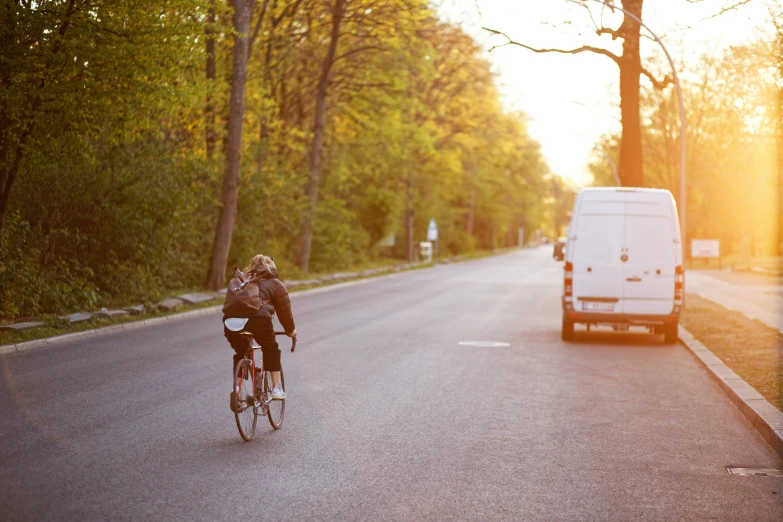 a man riding a bicycle down the middle of the road