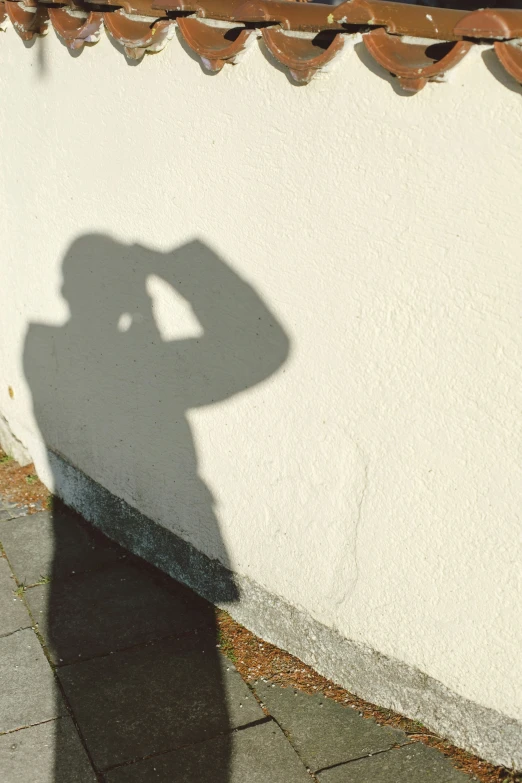 a person shadow on a wall next to a building