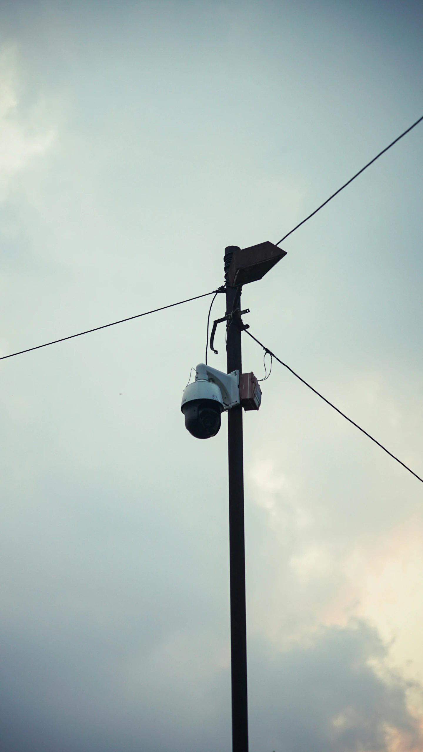 the light is hanging over the street from the power line