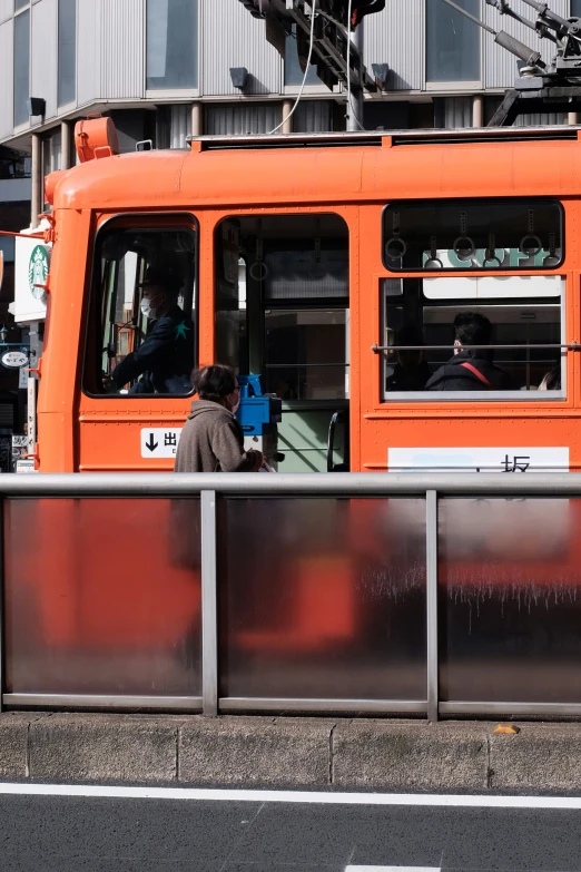 an orange cable car on a city street