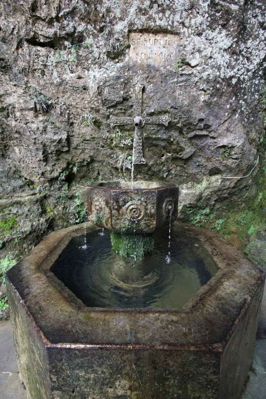 a fountain inside a stone cave near a rock wall