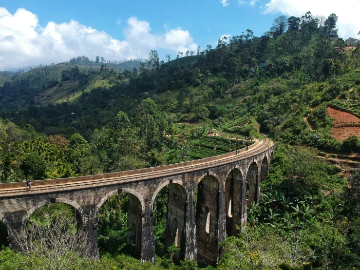 a train going over a bridge in the mountains