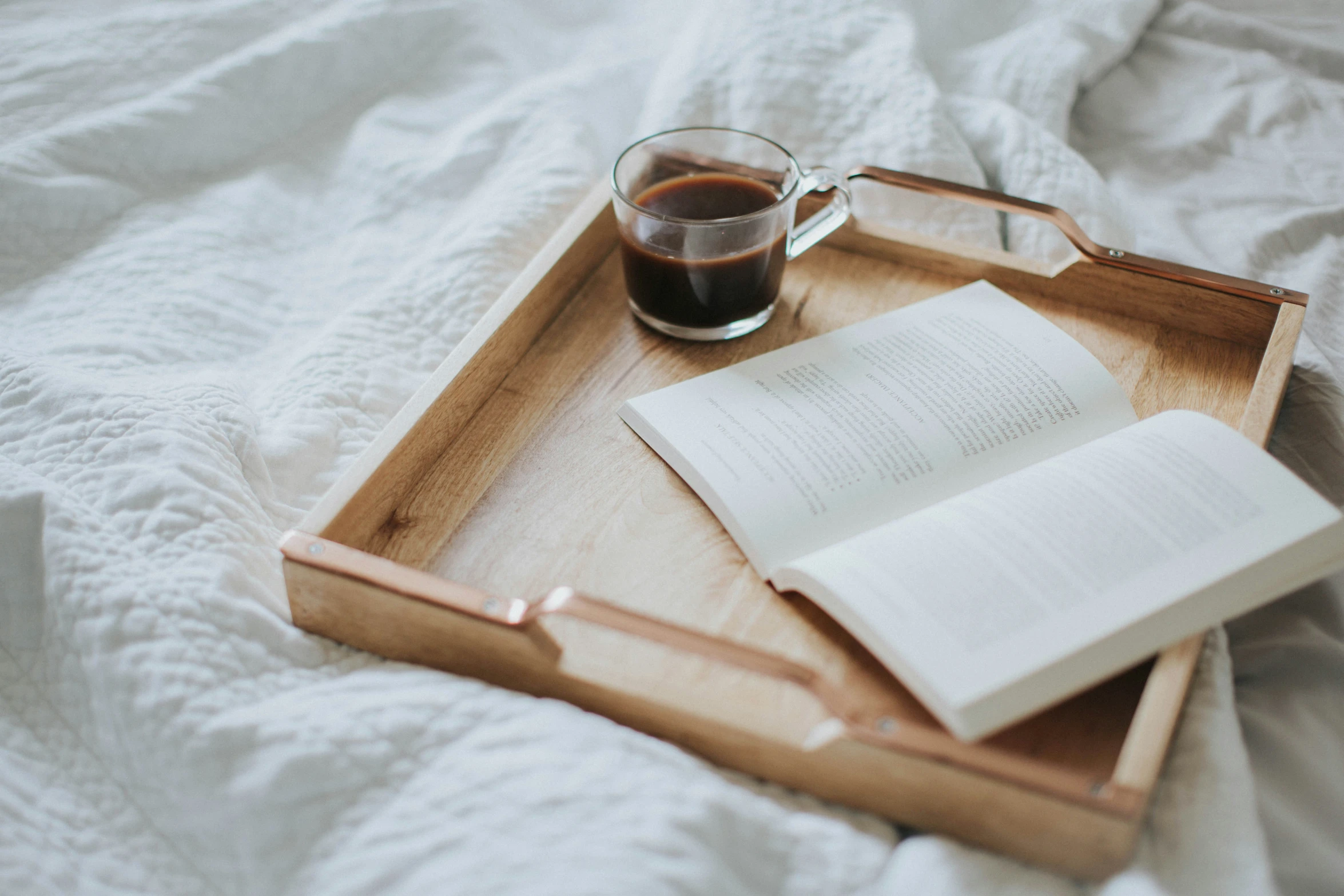 book on wooden tray with cup and spoon