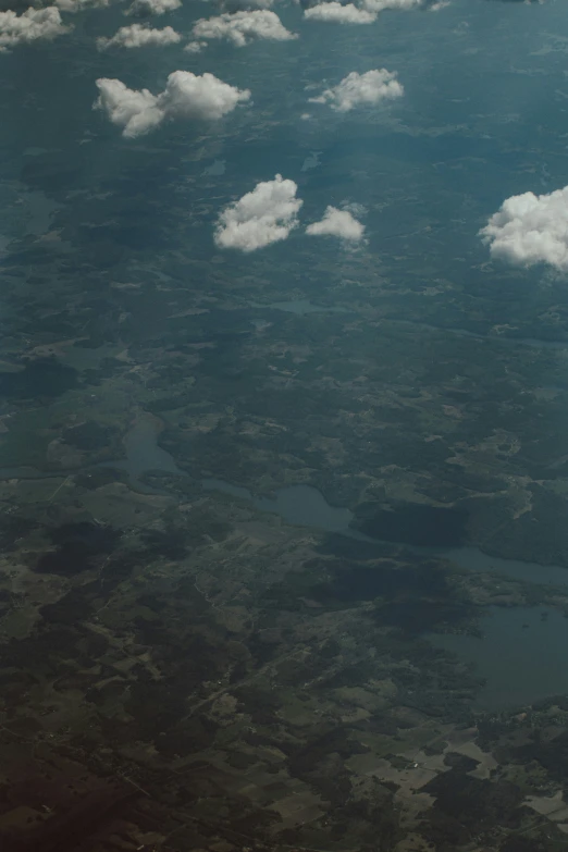 clouds and land seen from the sky, are shown from an airplane