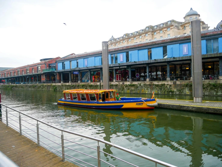 a yellow and blue boat moving through a waterway