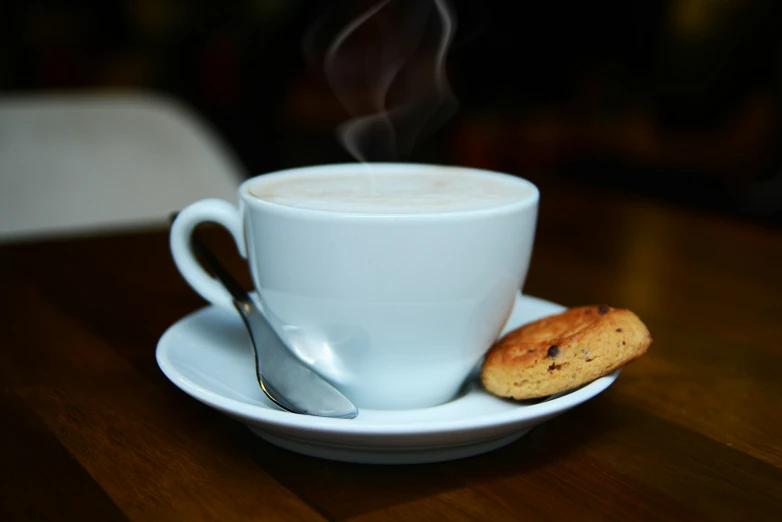 a cup filled with liquid sitting on top of a white saucer