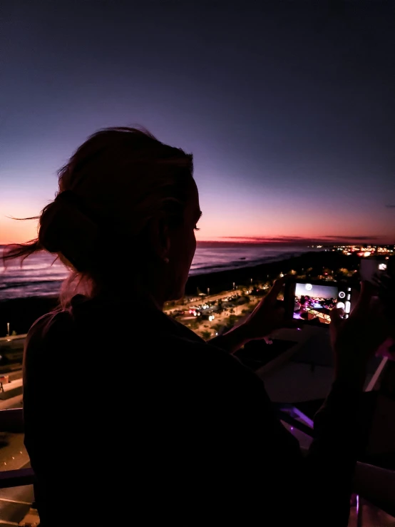 the woman is looking out over the ocean and town