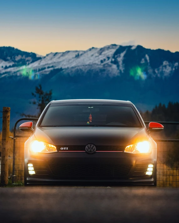 an automobile parked in front of a fence on the side of a road