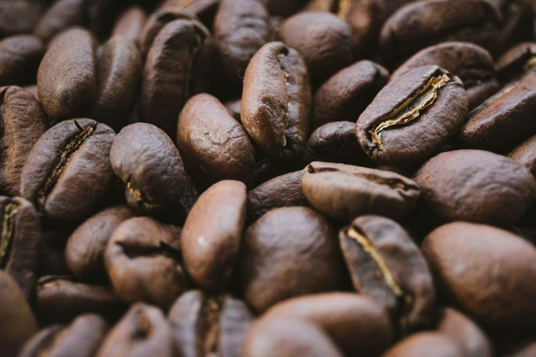 a close up of several coffee beans with gold stripes