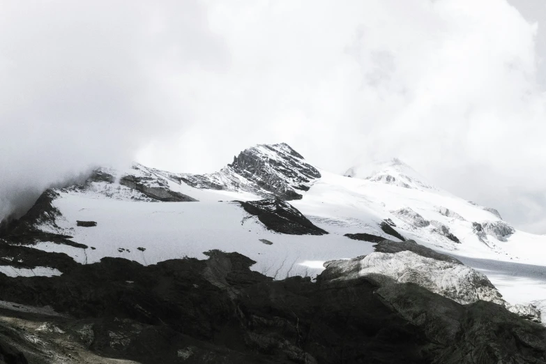 there is a snow covered mountain with clouds