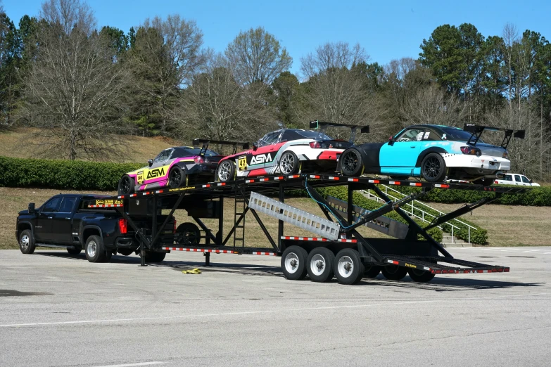 car carrier being loaded onto a large flatbed truck