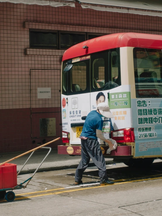 a man with a large hand is washing a bus