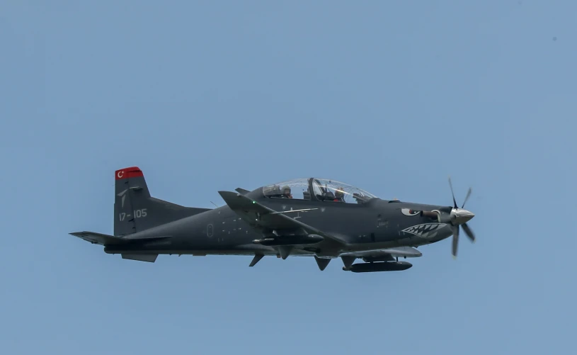 an air plane flies through the sky over the ground