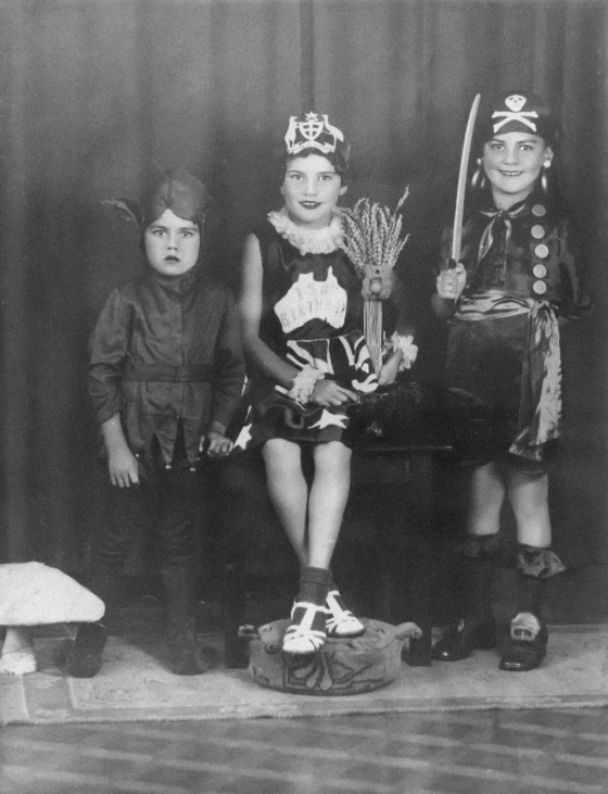 three children wearing costume and some holding tennis racquets